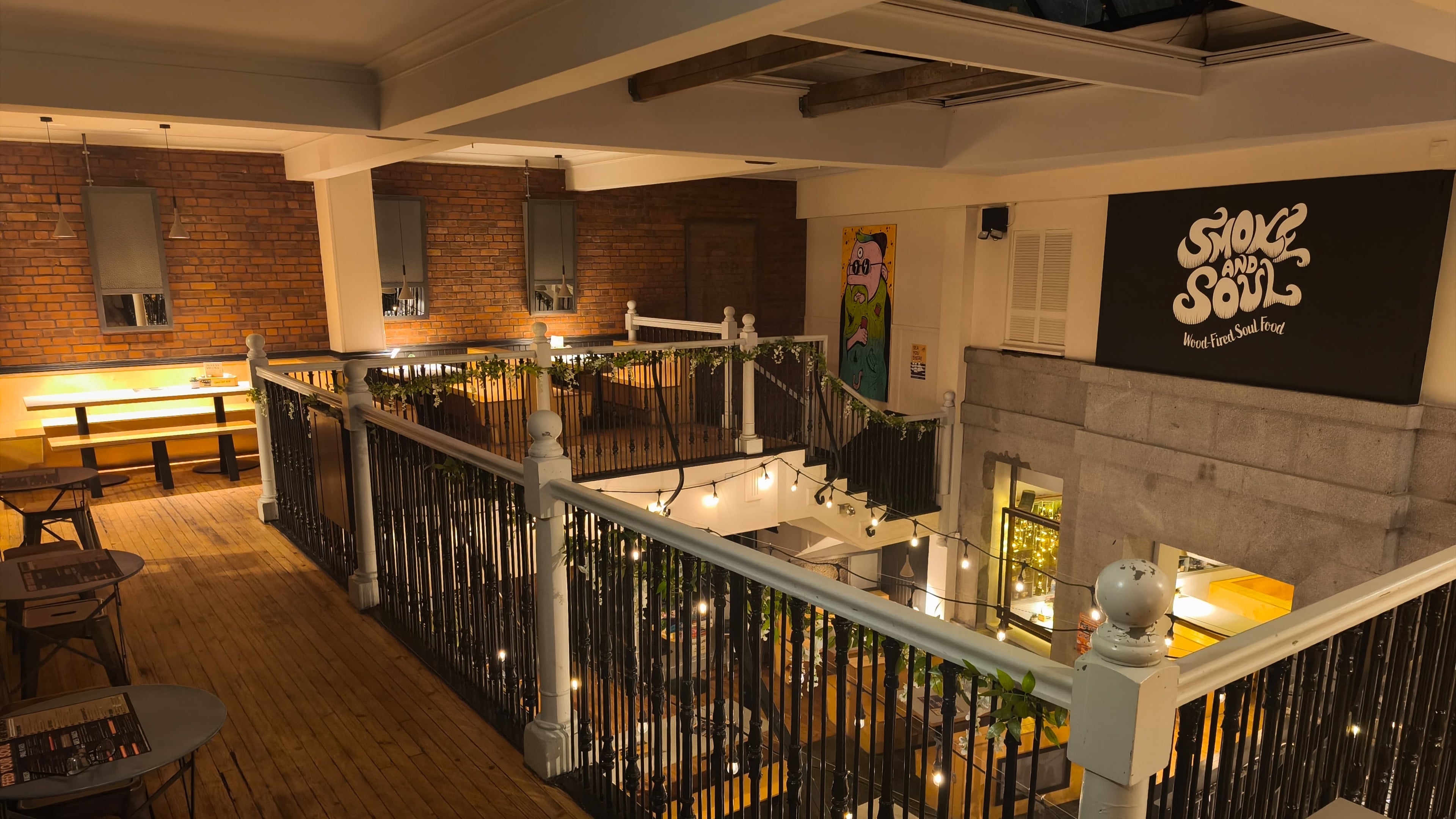 Restaurant interior with a balcony and 'Sides of the Soul' sign.